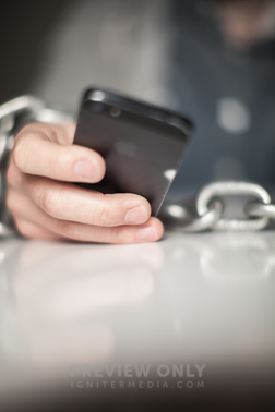 Wrists Bound With Chain Holding A Cell Phone. - Stock Photos | Pearl