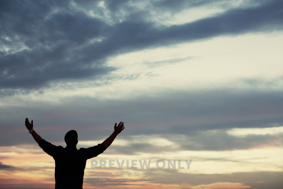 Silhouette Of A Man Standing Outside With Arms Raised In Praise ...