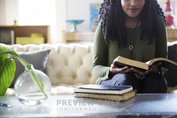 An African American Woman Reading A Bible In A Living Room - Stock ...