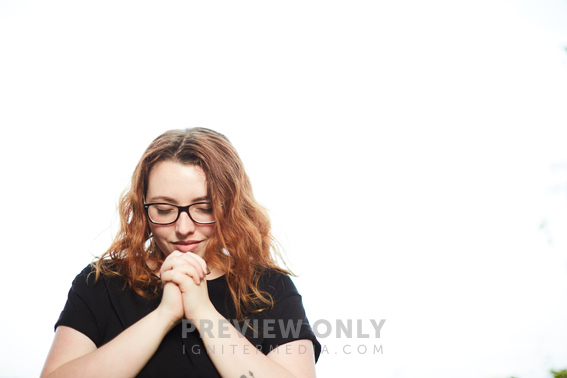 A Young Woman With Head Bowed In Prayer - Stock Photos | Prixel Creative